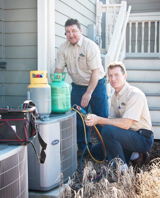 Workers working on a central air unit.